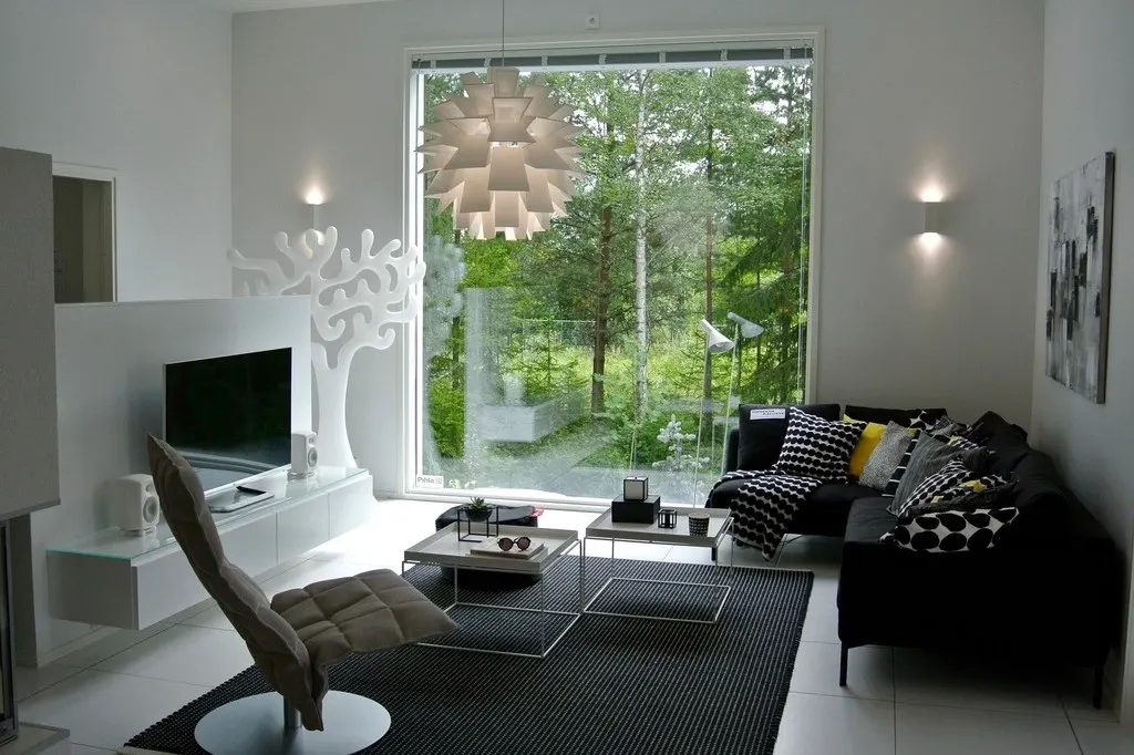 Wohnbereich mit Sofa und großen Fenstern