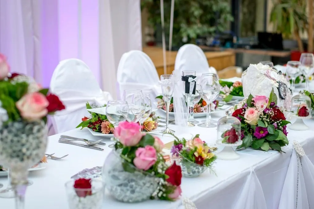 Hochzeitsdinner mit Blumen auf jedem Tisch