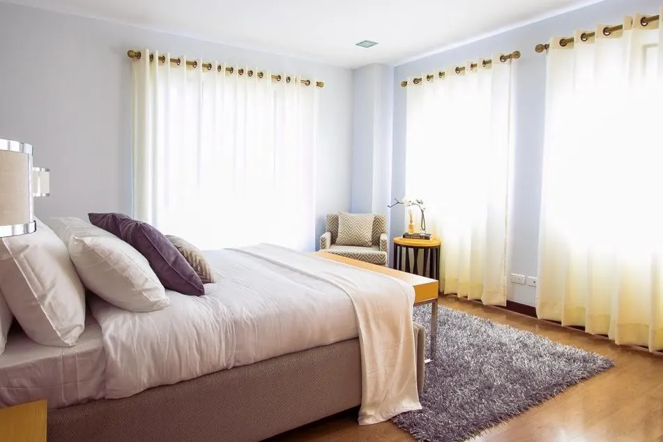 Schlafzimmer mit heller Bettwäsche